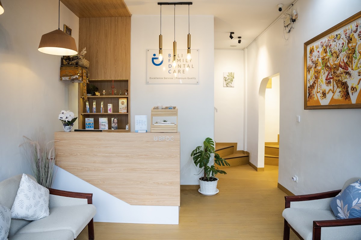 Bali Family Dental Care welcoming reception area with wooden BFDC-branded front desk and Balinese decor