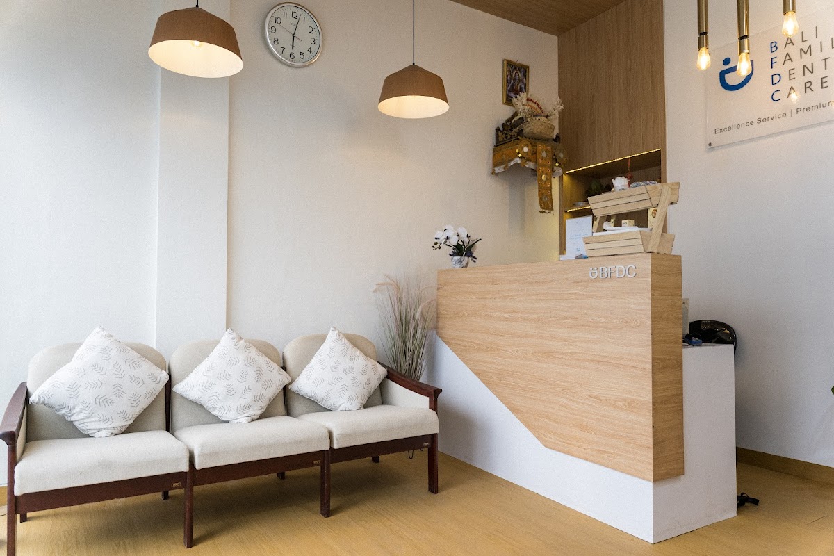Comfortable waiting lounge at Bali Family Dental Care with branded reception desk and pendant lighting