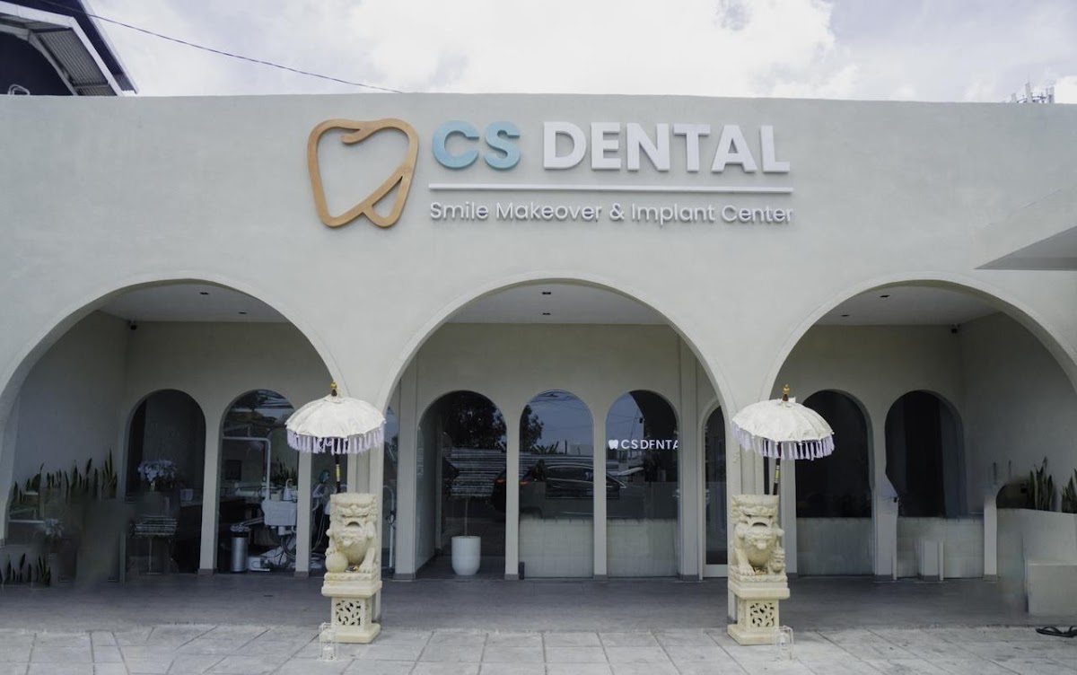 CS Dental Canggu white-arched facade with prominent signage and Balinese guardian statues