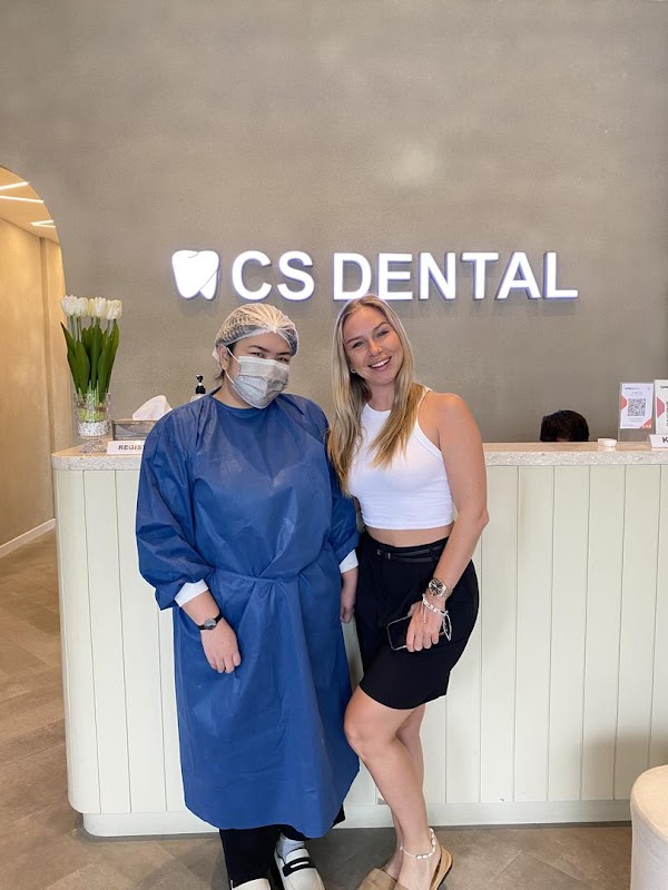 CS Dental Kuta reception area with illuminated signage, staff at front desk, and modern interior design