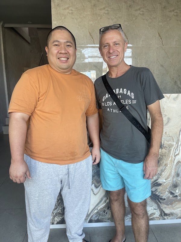 Dentist and satisfied patient sharing a warm smile together in the Flash Dental Bali lobby