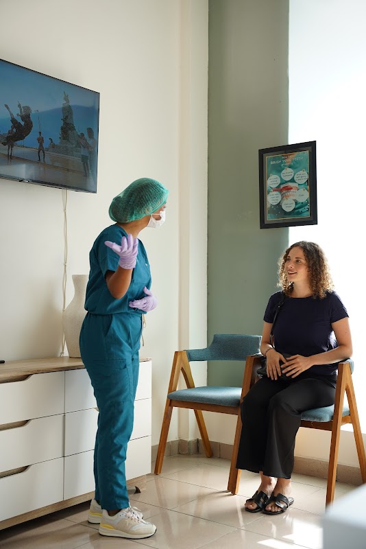 Friendly KALM Dental Care staff member consulting with a smiling patient in the waiting area