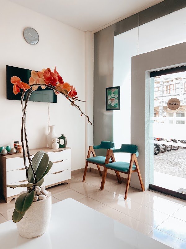 Stylish and welcoming waiting area at KALM Dental Care Bali with teal chairs and natural light