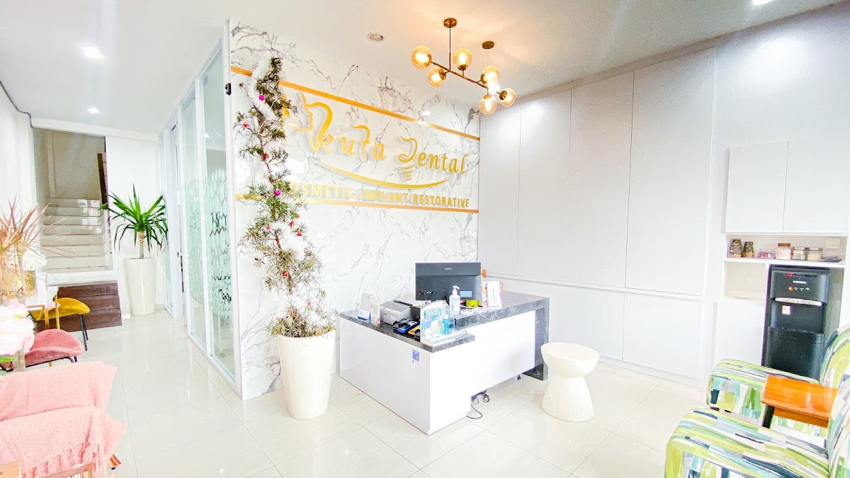 Kuta Dental bright modern reception area with marble wall, gold branding, and chandelier