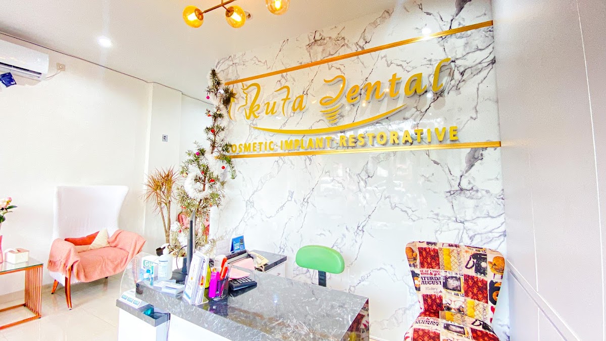 Kuta Dental elegant reception with marble accent wall, gold signage, and stylish lighting