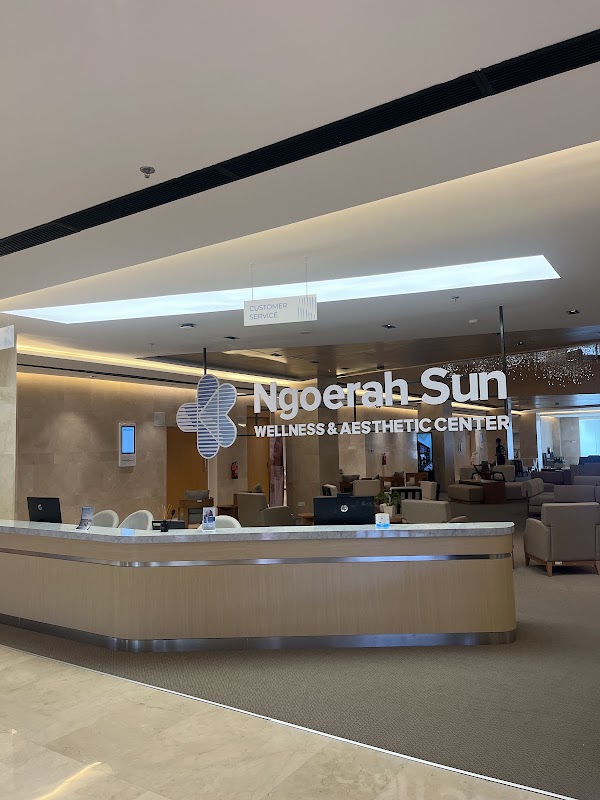 Modern and elegant reception area featuring a marble front desk, warm lighting, and comfortable lounge seating.