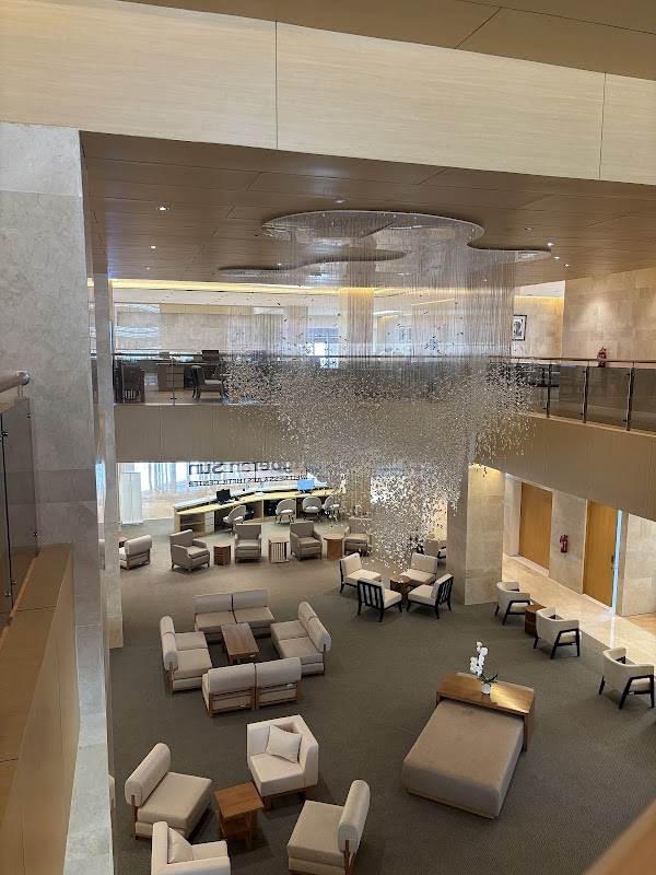 Stunning double-height lobby with modern furniture, elegant chandelier installation, and luxurious marble finishes showcasing the upscale wellness center interior.