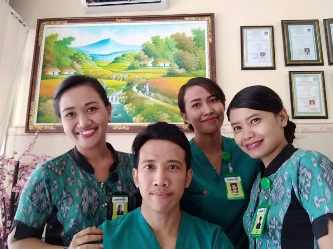 Dental team at Puri Medical Clinic smiling with certificates and artwork on wall
