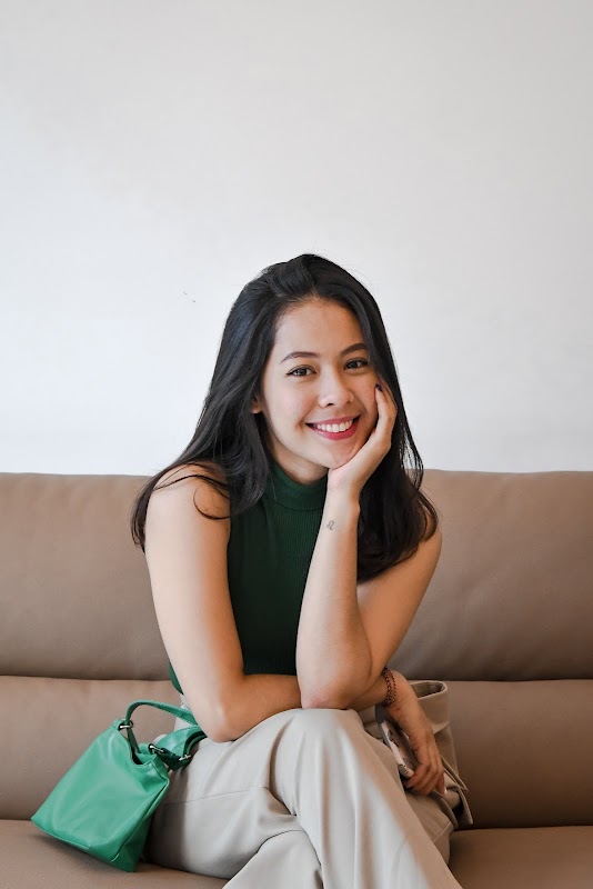 Happy patient with handbag smiling in waiting room at Smile Ready Bali
